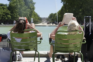 two women sitting on green chairs