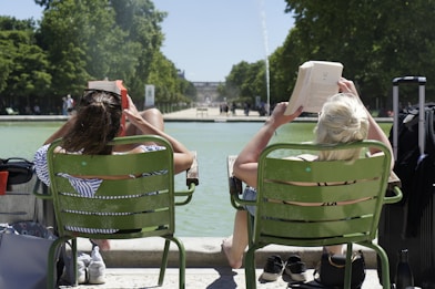 two women sitting on green chairs