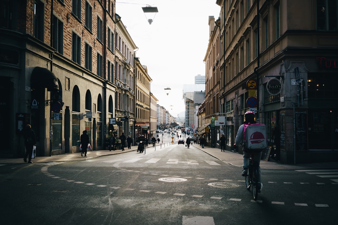 man riding on black bike towards gray road