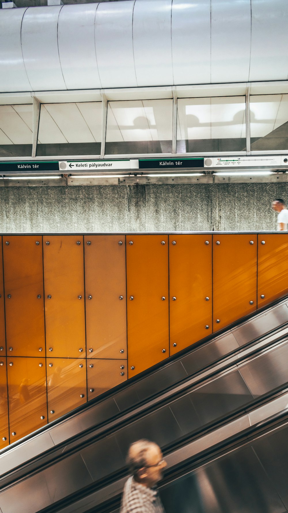 man standing on escalator