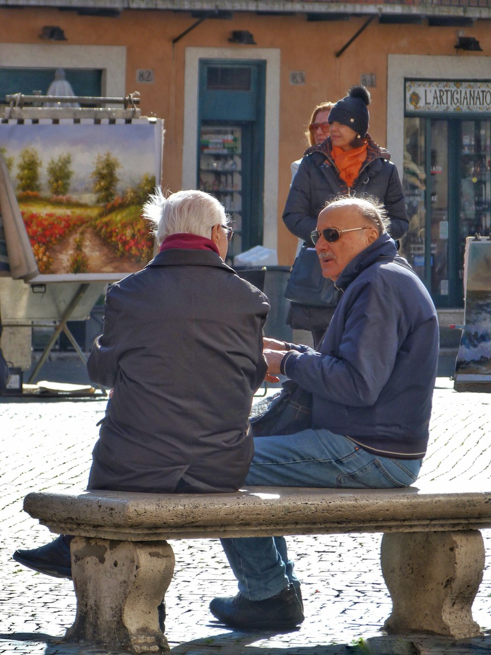 コンクリートのベンチに座っている人の浅い焦点の写真