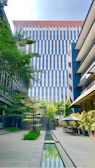 Modern commercial courtyard featuring vertical green walls and aquatic water features.