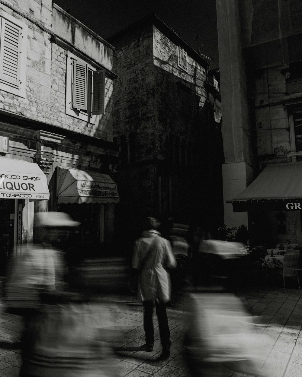 a black and white photo of people walking down a street