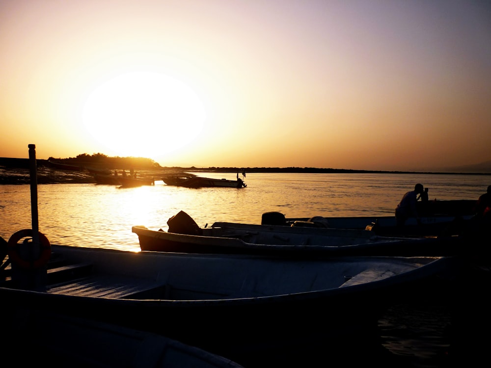 Fotografia di silhouette di barche sullo specchio d'acqua