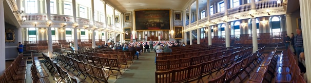 A dignified gathering of lodge members in ceremonial regalia inside a historic meeting hall.