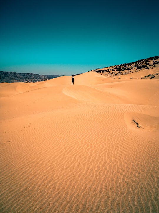 person standing on desert dune in Essaouira Province Morocco