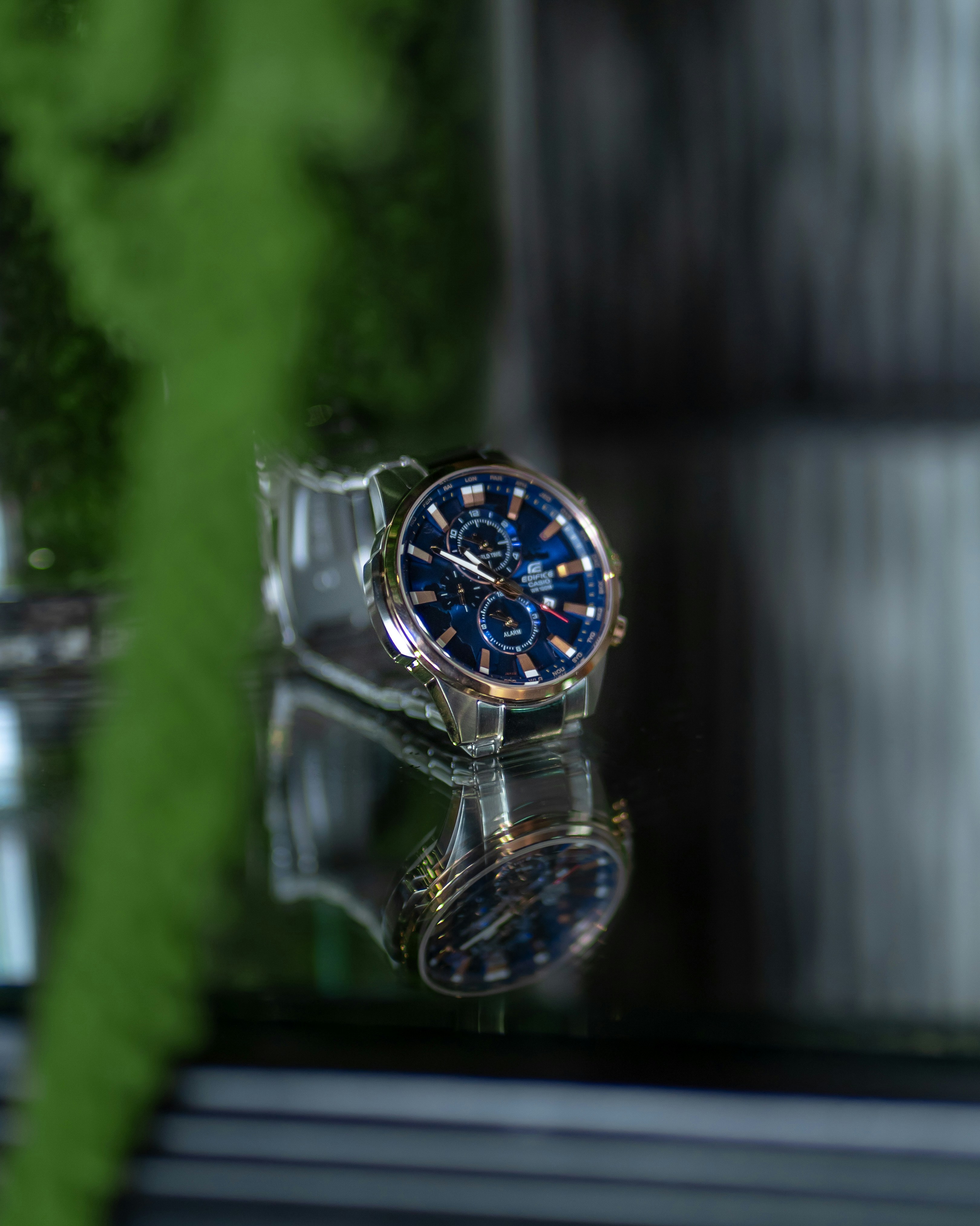 Un reloj sentado encima de una mesa de cristal