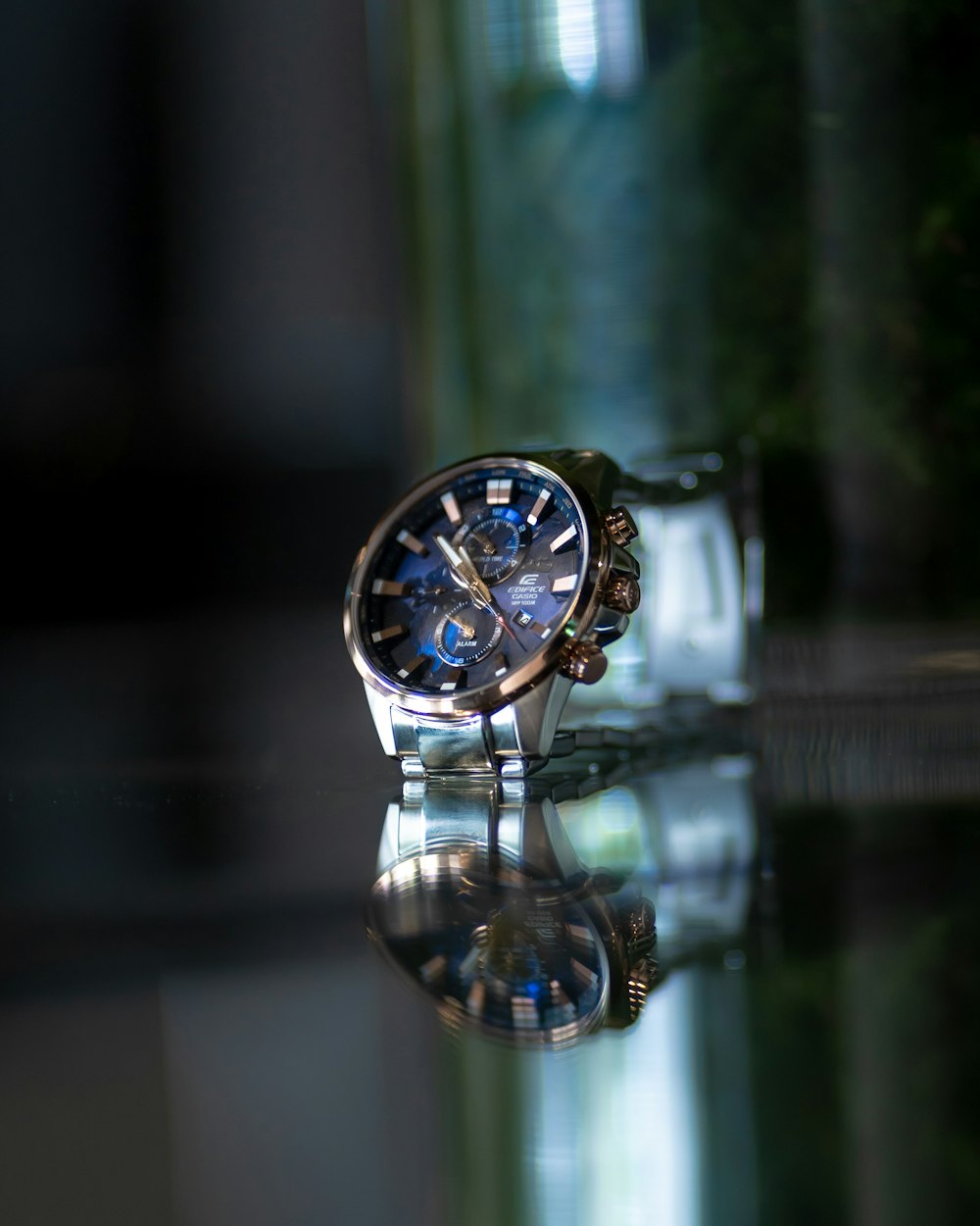 selective focus photography of round black and silver-colored chronograph watch