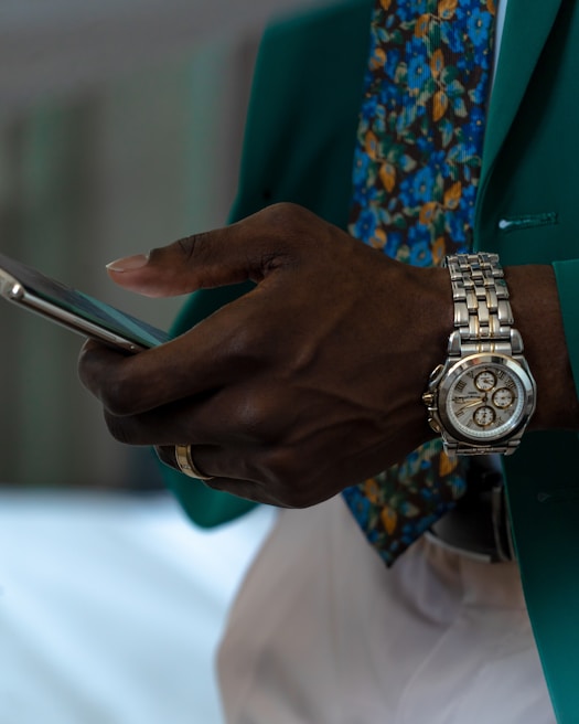 A close-up of trendy accessories including a smartphone and elegant jewelry.
