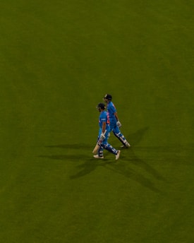 a couple of men standing on top of a lush green field