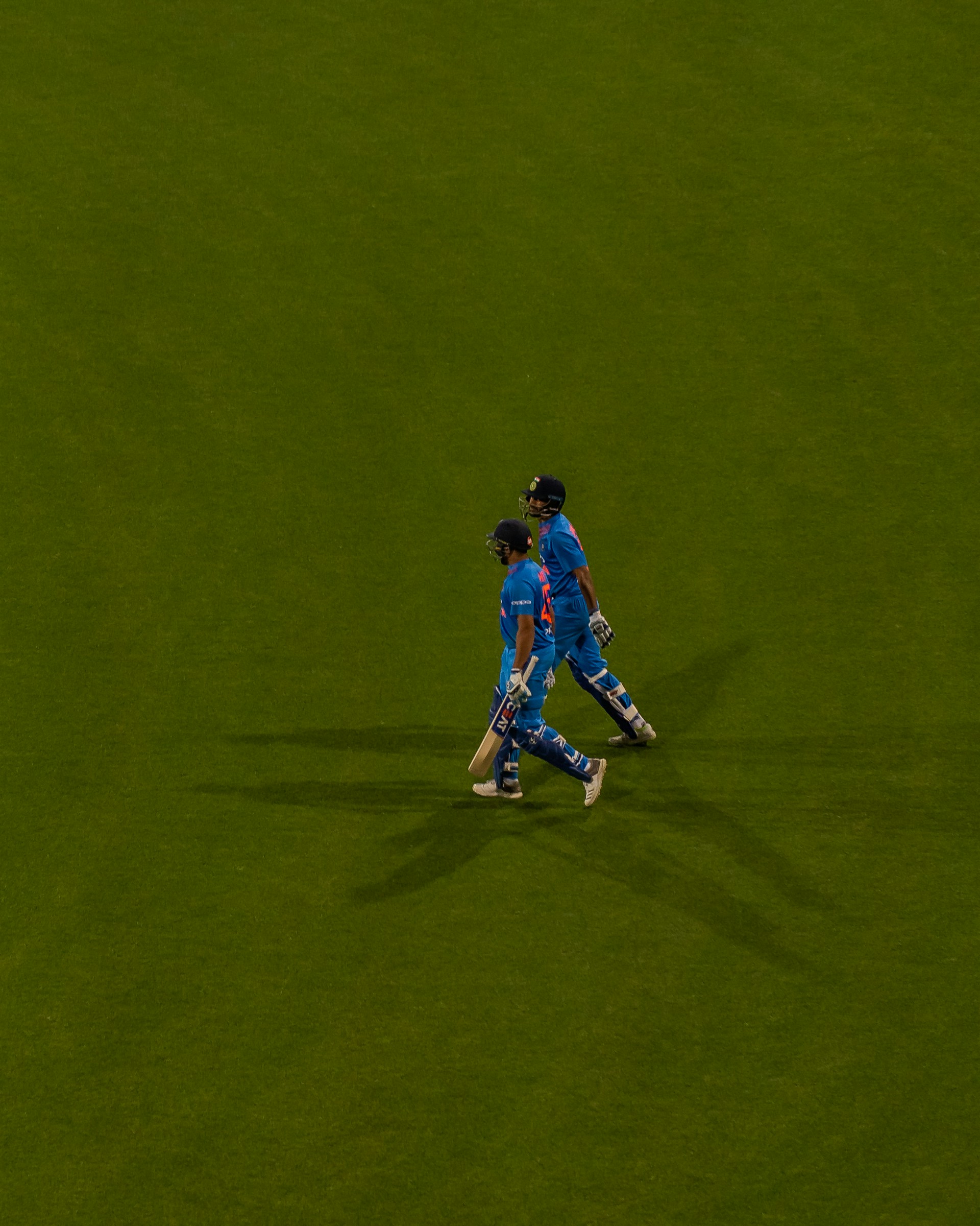 a couple of men standing on top of a lush green field