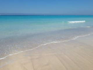 A tranquil beach in Bali with clear blue waters.