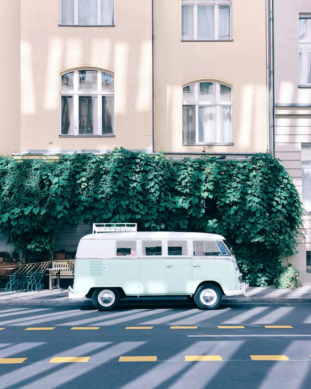 green and white bus parking near concrete building