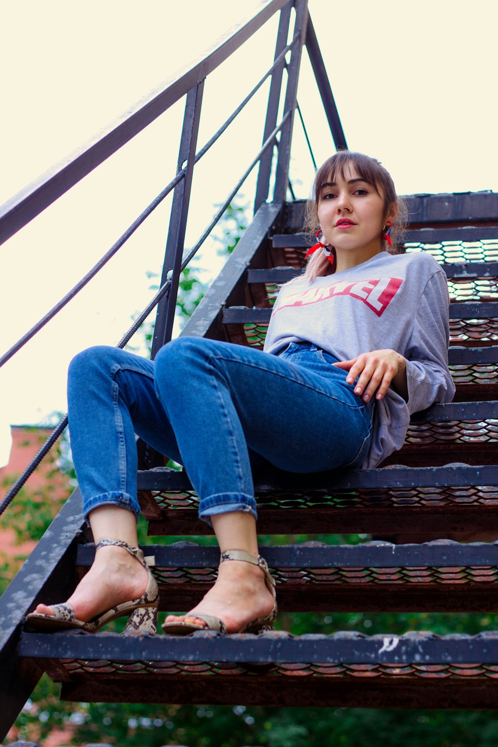 woman wearing grey jacket sitting on stair