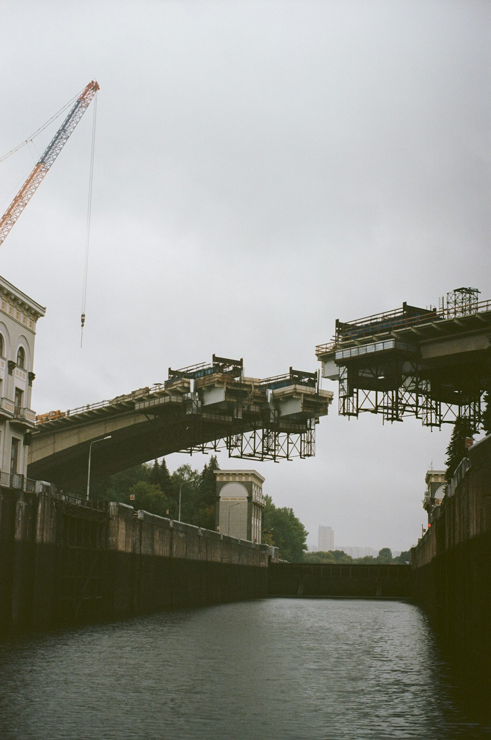 a crane is on a bridge over a body of water