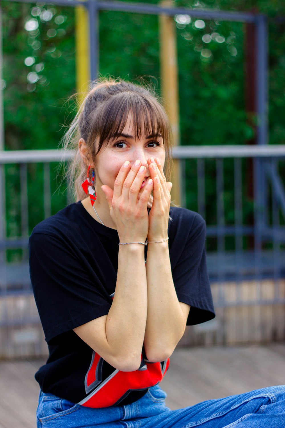 a woman sitting on the ground covering her mouth