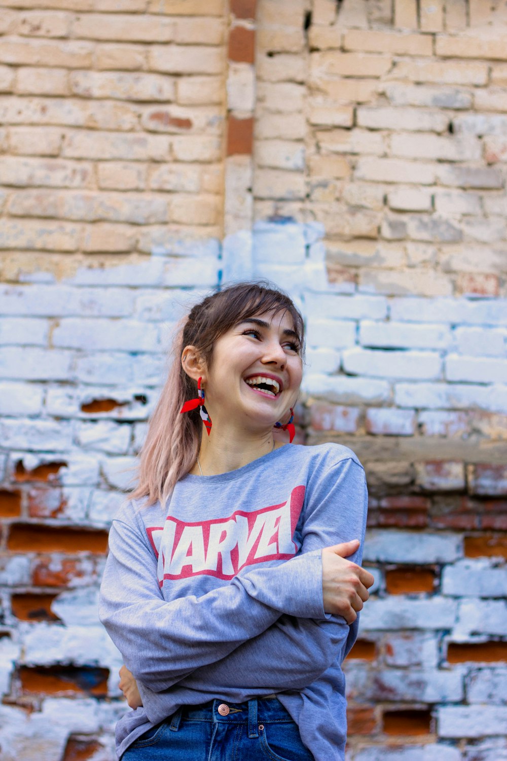 a woman standing in front of a brick wall