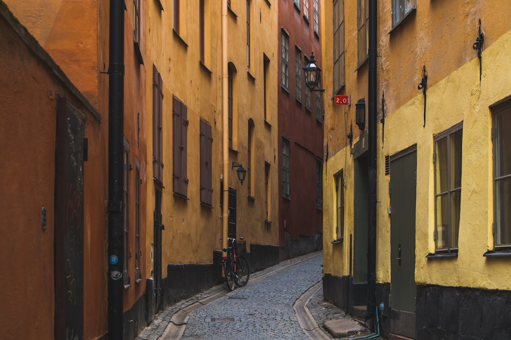 a cobblestone street lined with yellow buildings