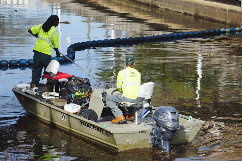 Workers collecting rubbish from a river