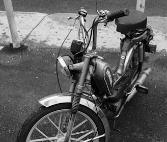 grayscale photo of moped bike on street