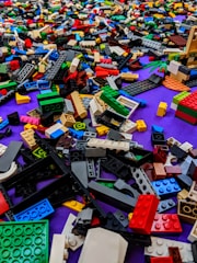 Close-up of colorful Lego brick earrings arranged on a vibrant background.