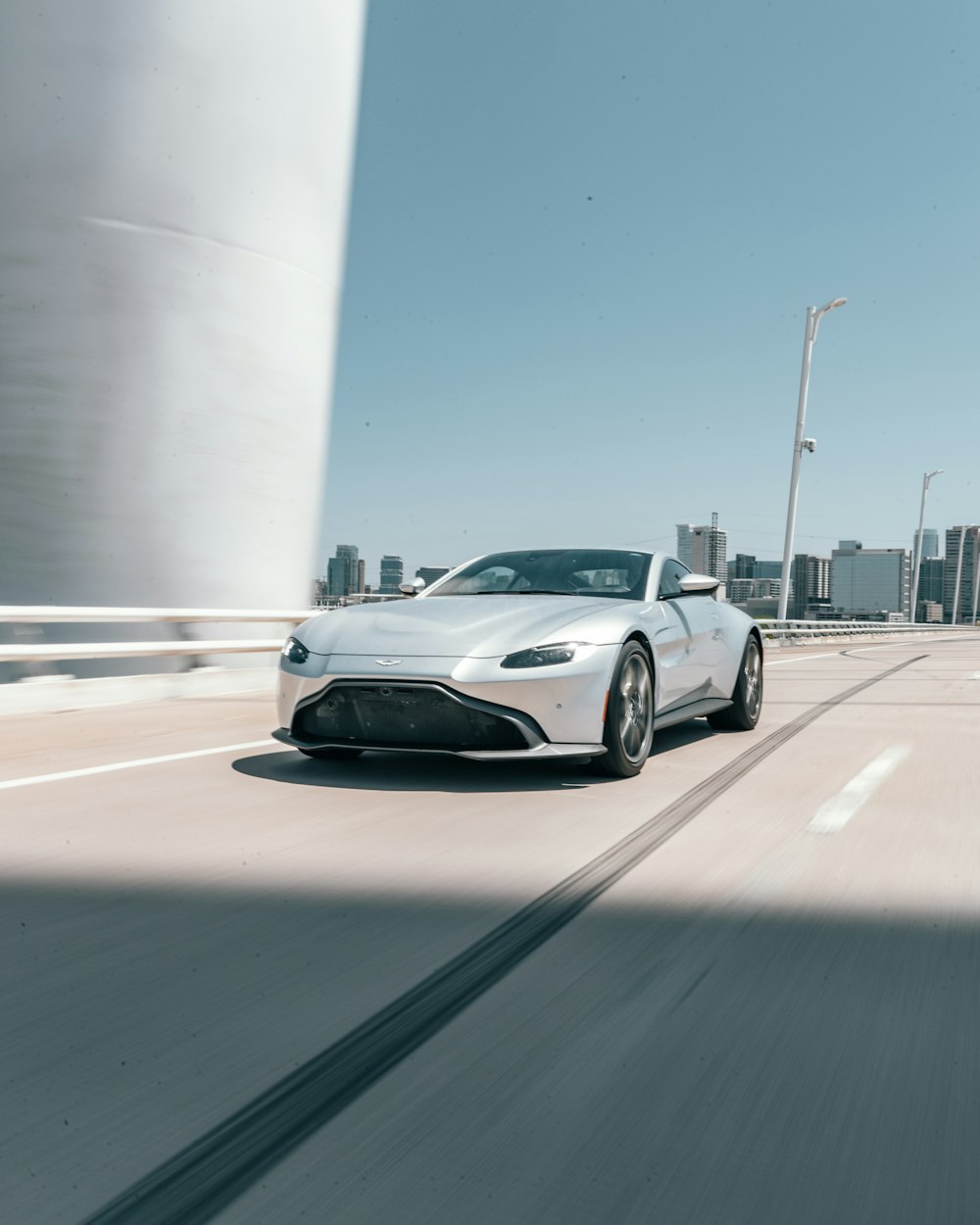 silver Aston Martin coupe runnin on road