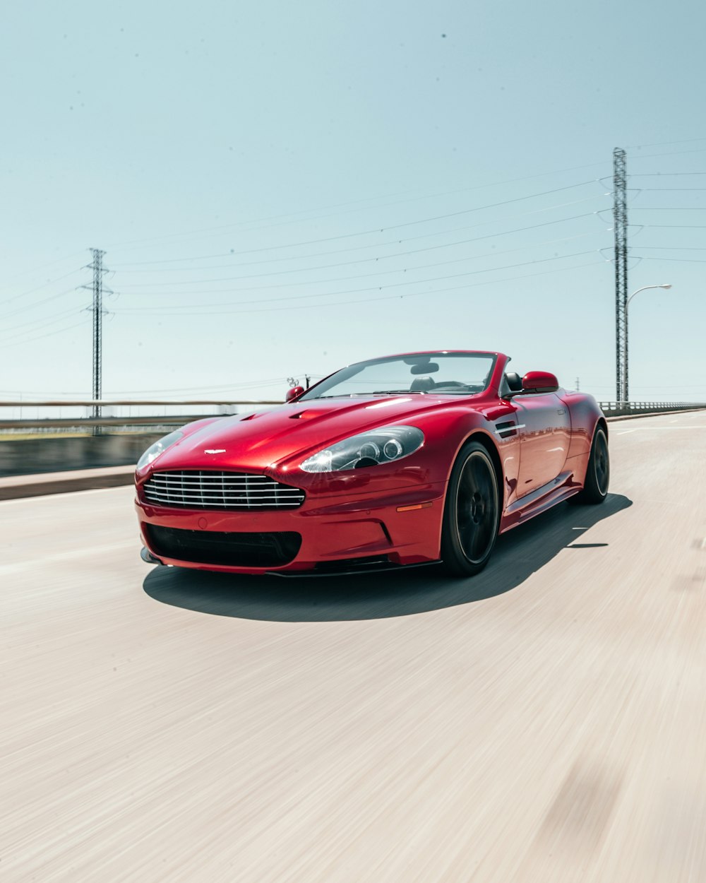 red Aston Martin Vantage running on road