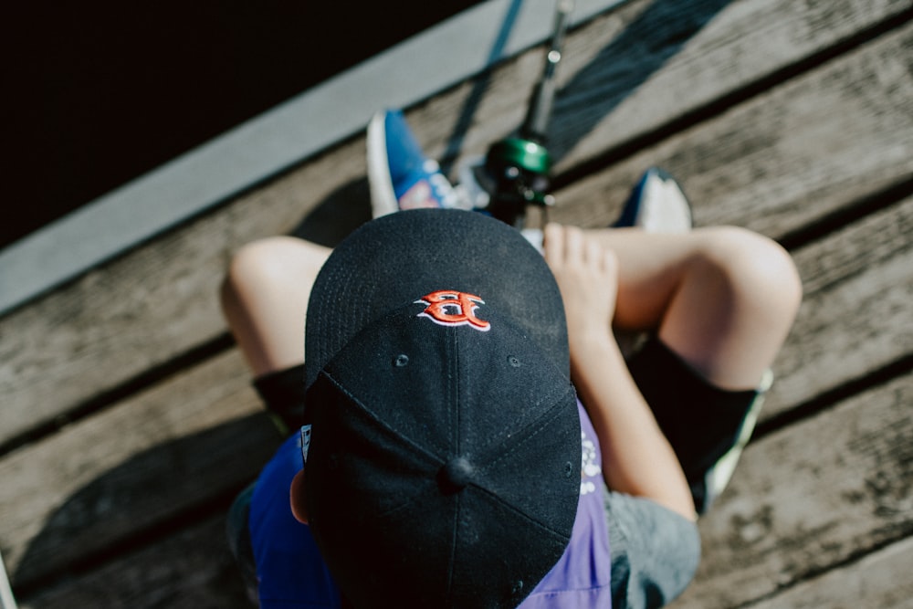 person wearing black cap holding fishing rod