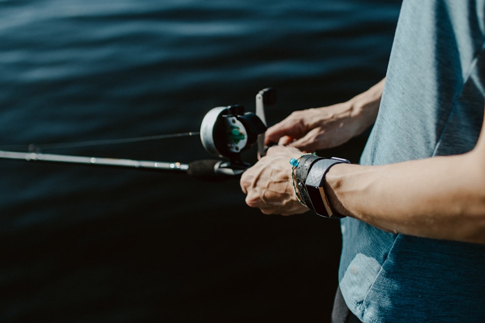 a man holding a fishing rod and a reel