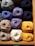 Close-up of colorful yarn skeins neatly arranged on wooden shelves in a cozy shop.