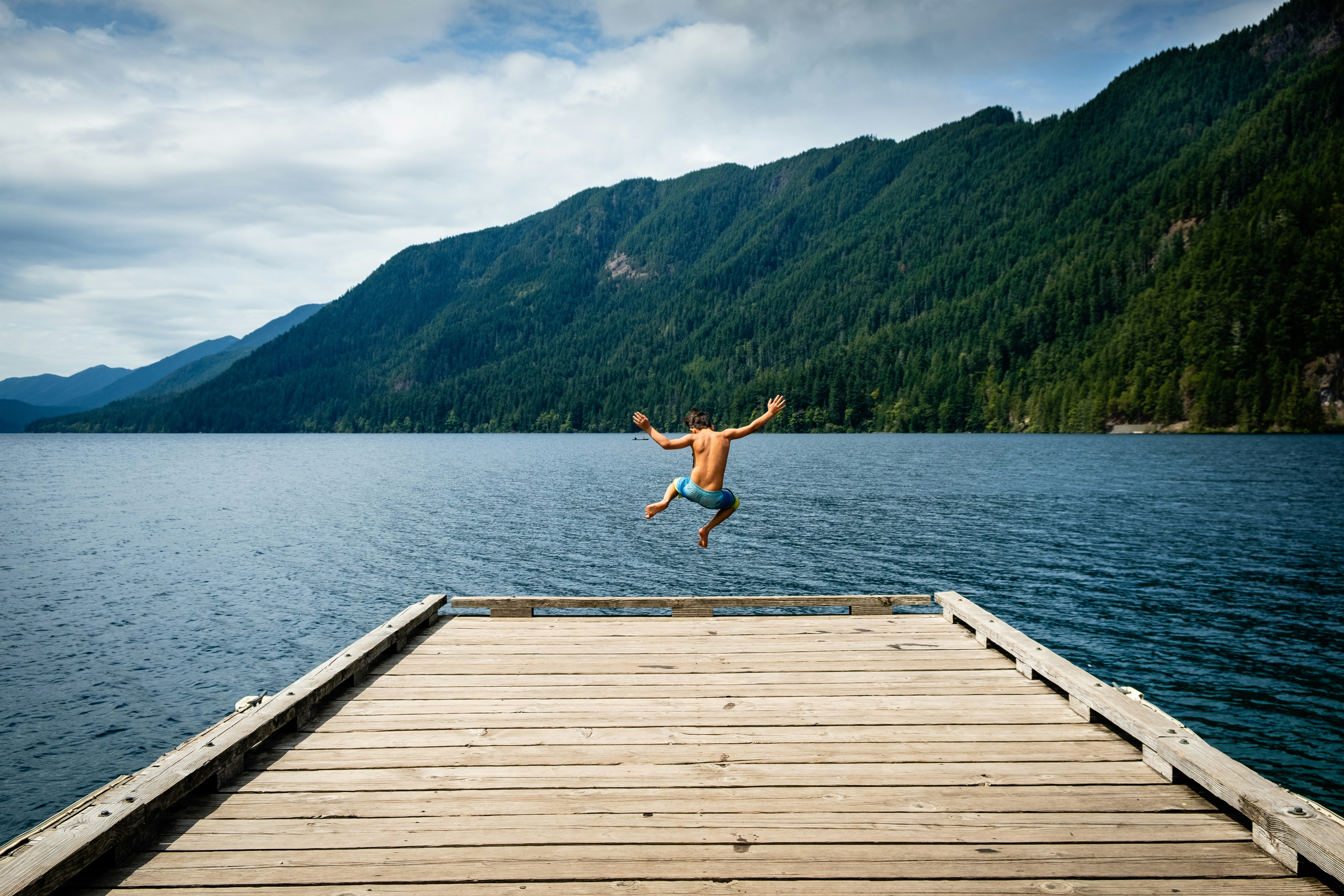 man jumping near sea