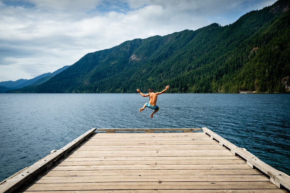 man jumping near sea