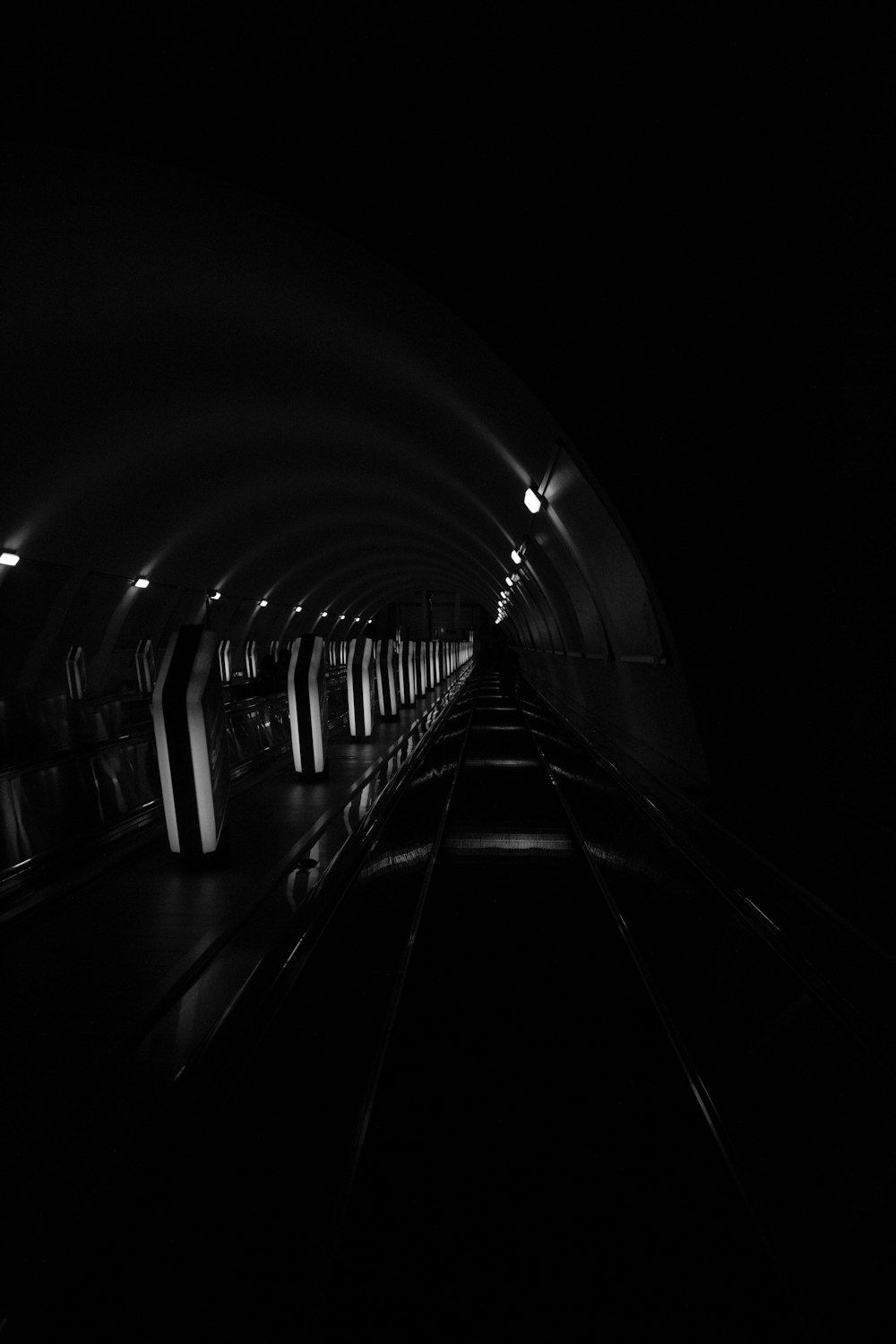 greyscale photography of tunnel road