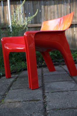 A colorful plastic folding chair in bright red, featuring a 'Get Price' button in front.