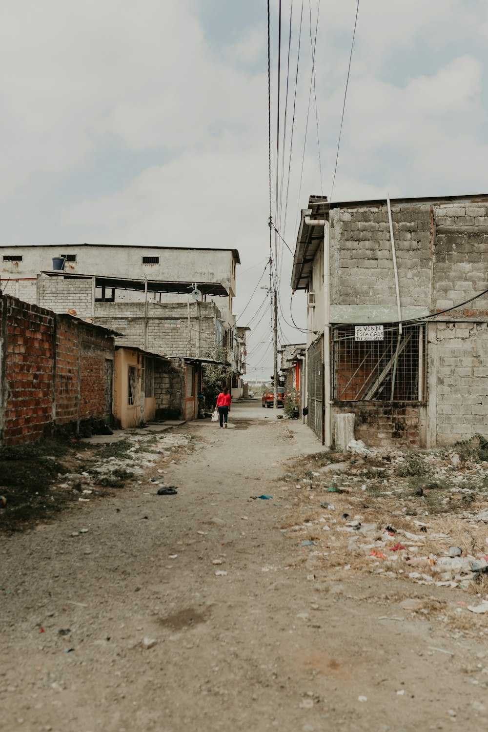 person walking near houses under white and blue skies