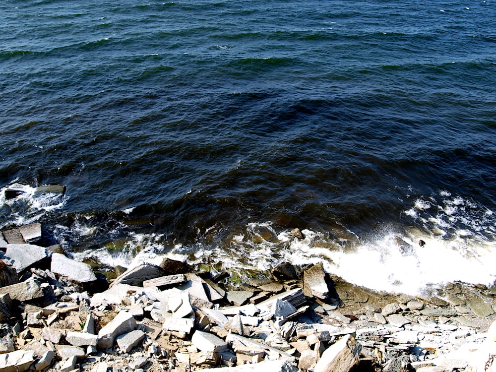 a view of a body of water with rocks on the shore