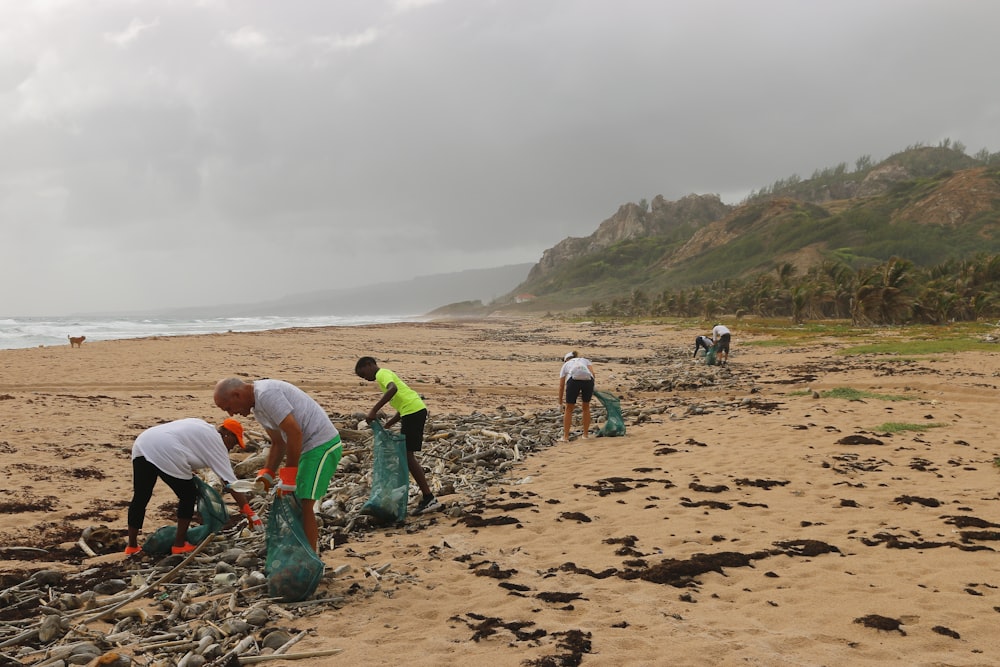 pessoas catando lixo perto da praia