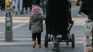 toddler walking beside stroller