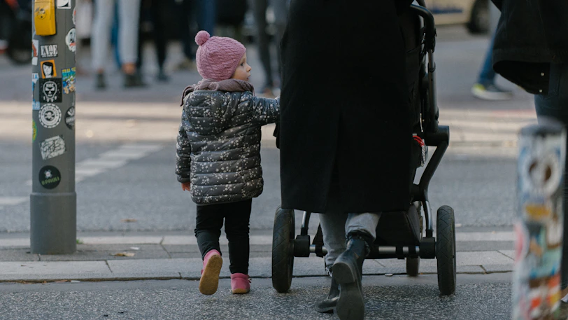 toddler walking beside stroller