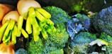 A close-up of fresh green broccoli heads and white radishes with their green stems, displaying a vibrant and healthy appearance.