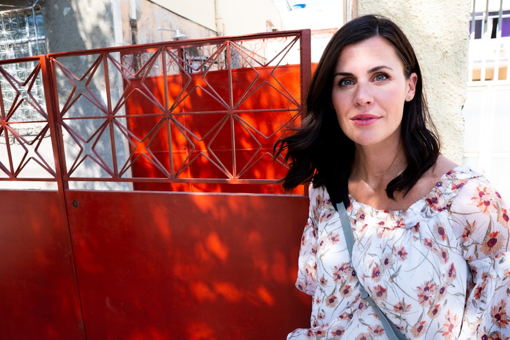 woman standing near red metal gate