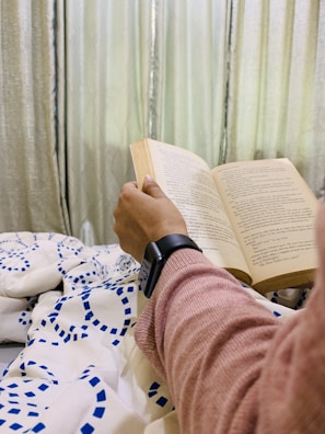 A woman studying a financial ebook on her tablet, surrounded by soft pink and brown decor.