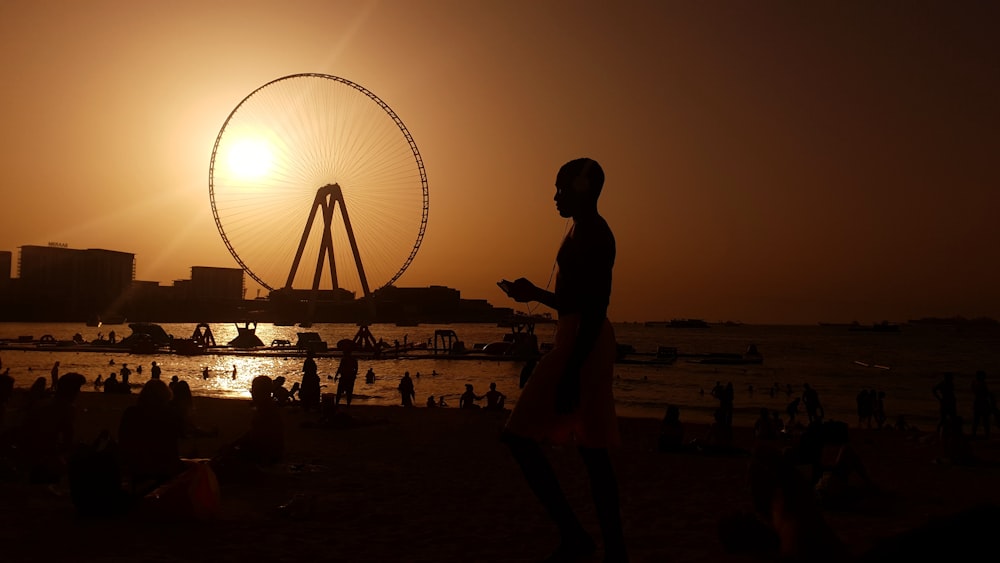 people at the amusement park on the beach during golden hour