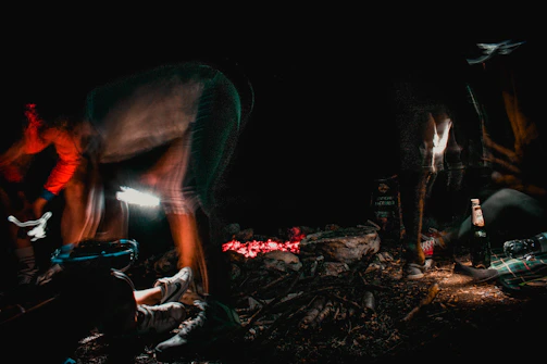 Nighttime dance around the campfire with shadows flickering and friends lost in the moment.