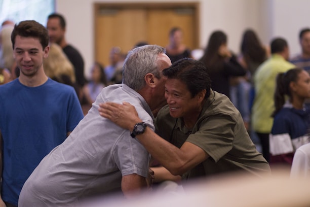 two men hugging on focus photography