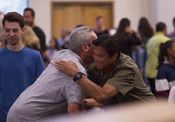 two men hugging on focus photography