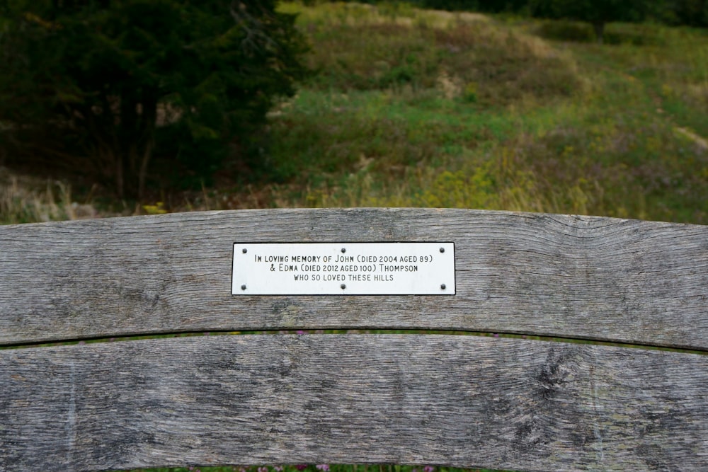 um banco de madeira com uma placa sobre ele