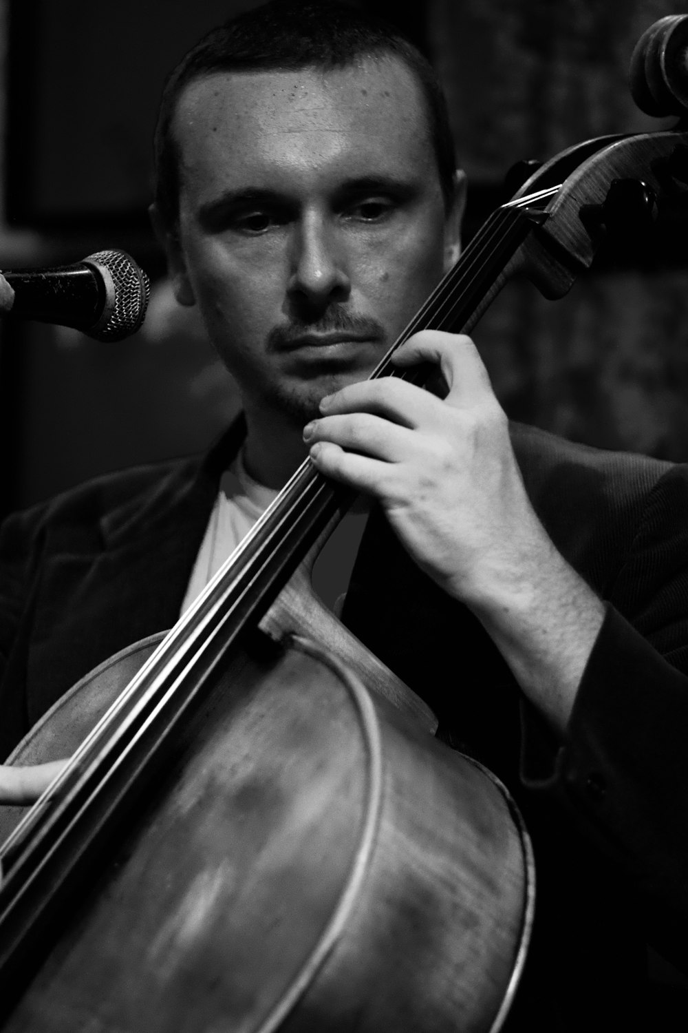 gray-scale photo of man playing cello