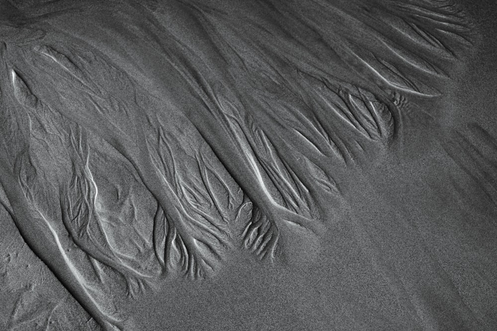 a black and white photo of sand and water