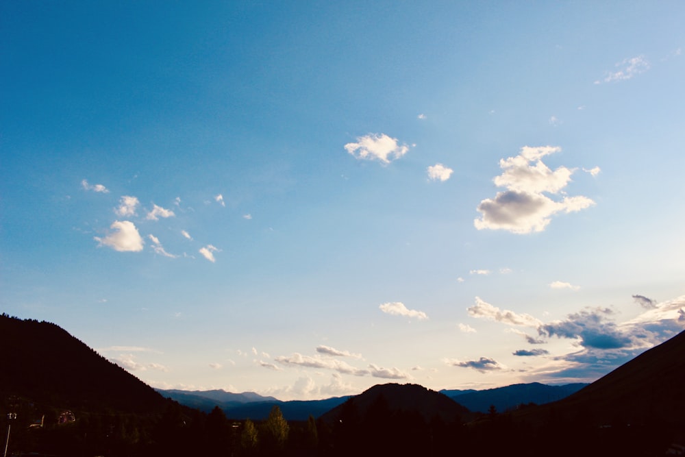 mountain under blue and white skies